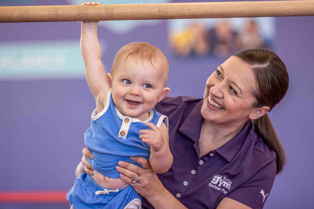 a little gym instructor holding a young boy