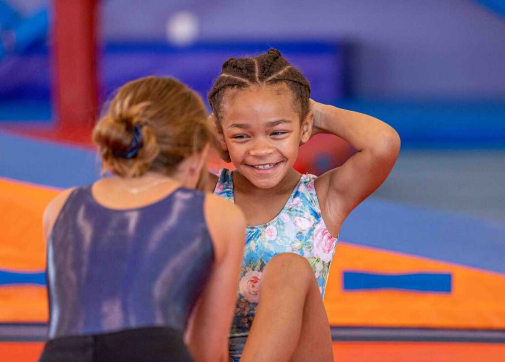 two young girls having fun in a gymnastics class