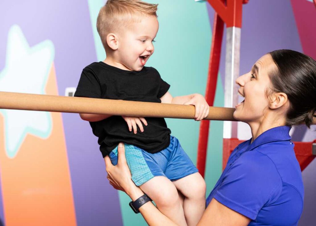 the little gym instructor with a young boy gymnast