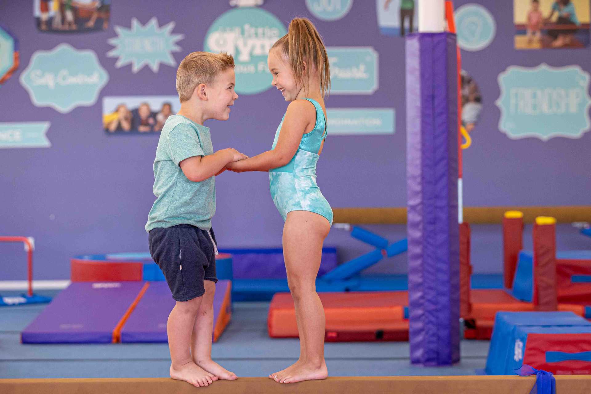 boy and girl on a gymnastics balancing beam