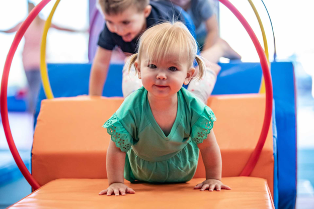 toddler girl crawling with a metal hoop